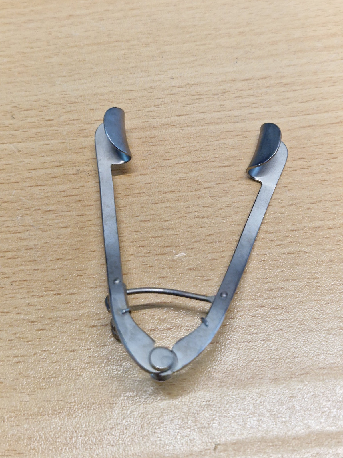 Rear view of adjustable ophthalmic eye speculum showing solid eyelid blades and spring mechanism