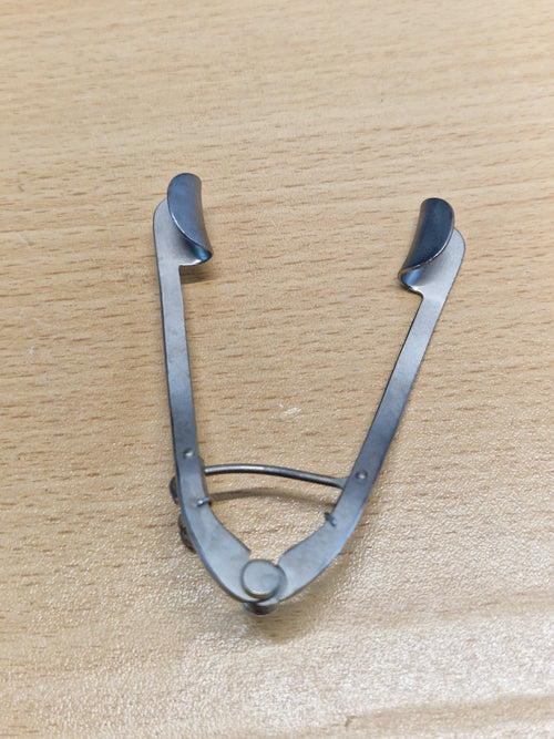 Rear view of adjustable ophthalmic eye speculum showing solid eyelid blades and spring mechanism