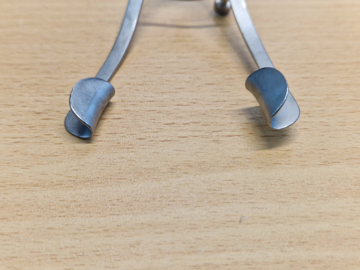 Close-up of solid curved blades on adjustable ophthalmic eyelid speculum