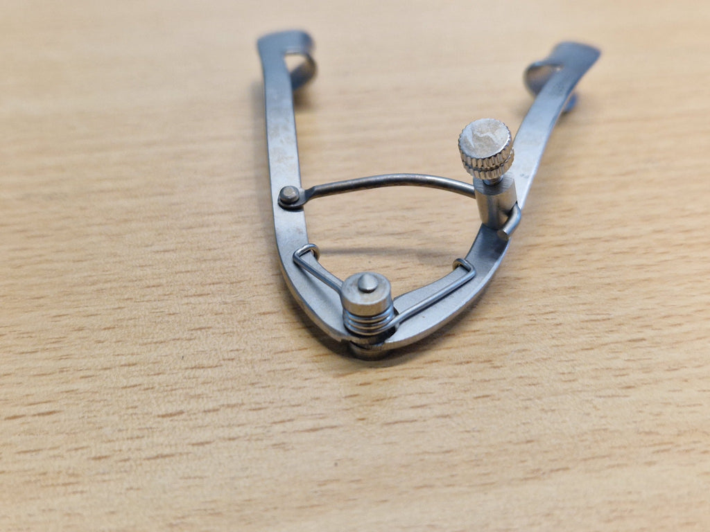 Adjustable ophthalmic eye speculum thumb screw and spring locking mechanism