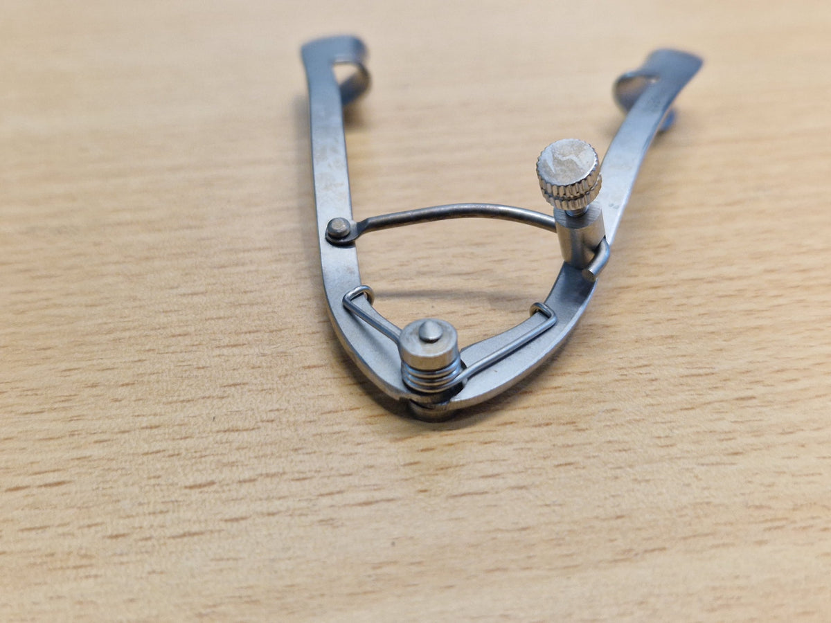 Adjustable ophthalmic eye speculum thumb screw and spring locking mechanism