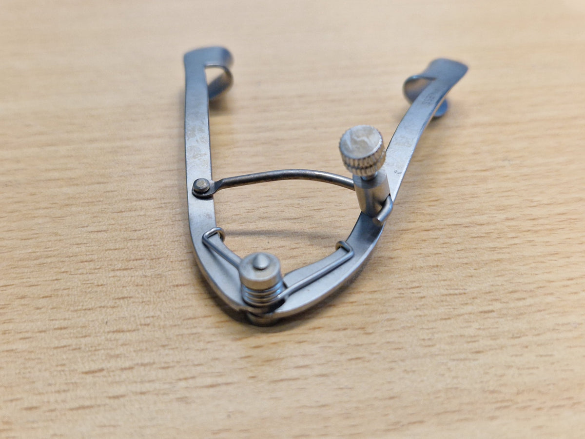 Adjustable solid-blade ophthalmic eye speculum with thumb screw locking mechanism