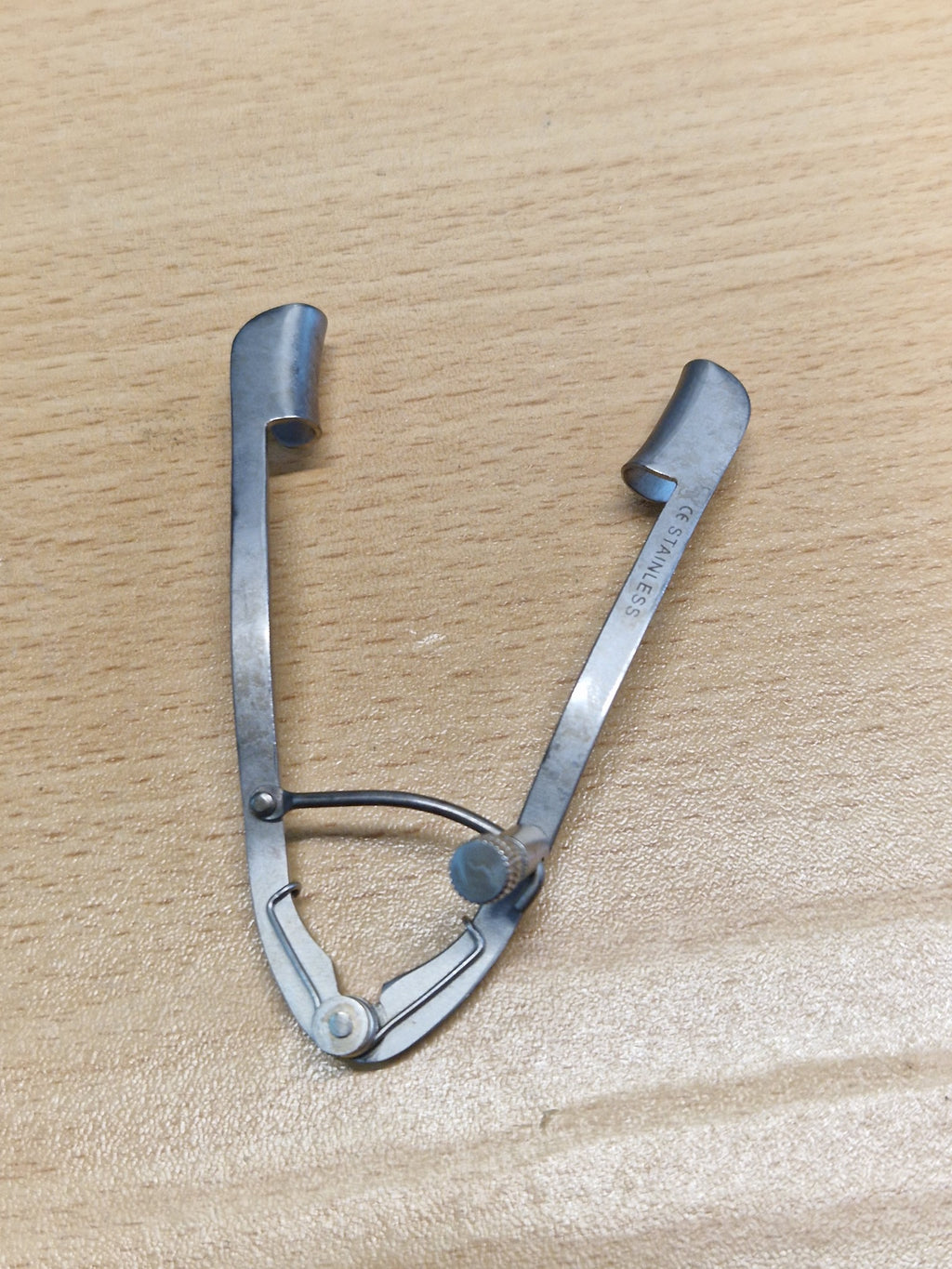 Open view of adjustable stainless steel ophthalmic eyelid speculum with solid curved blades