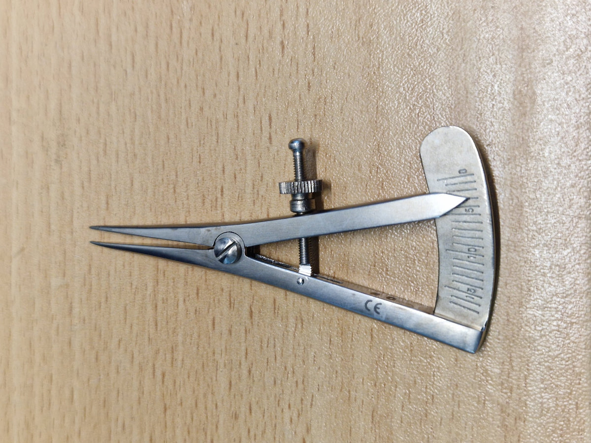 Castroviejo ophthalmic caliper showing adjustable screw and graduated millimetre scale