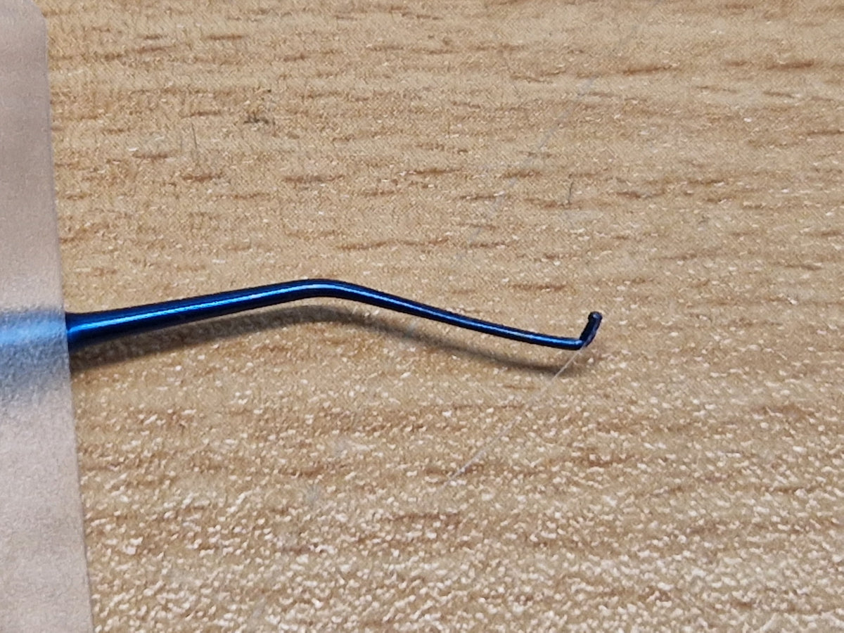 Angled shaft and fine hook tip detail of double-ended ophthalmic Sinskey-type instrument
