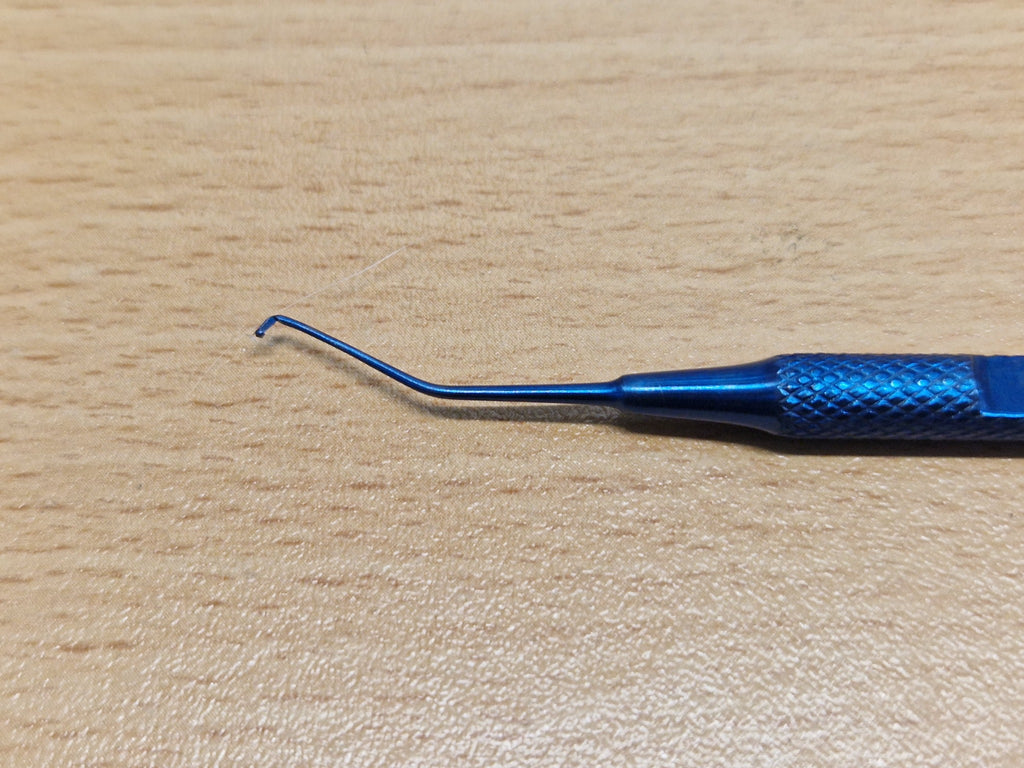 Close-up of fine angled hook on reusable double-ended ophthalmic instrument