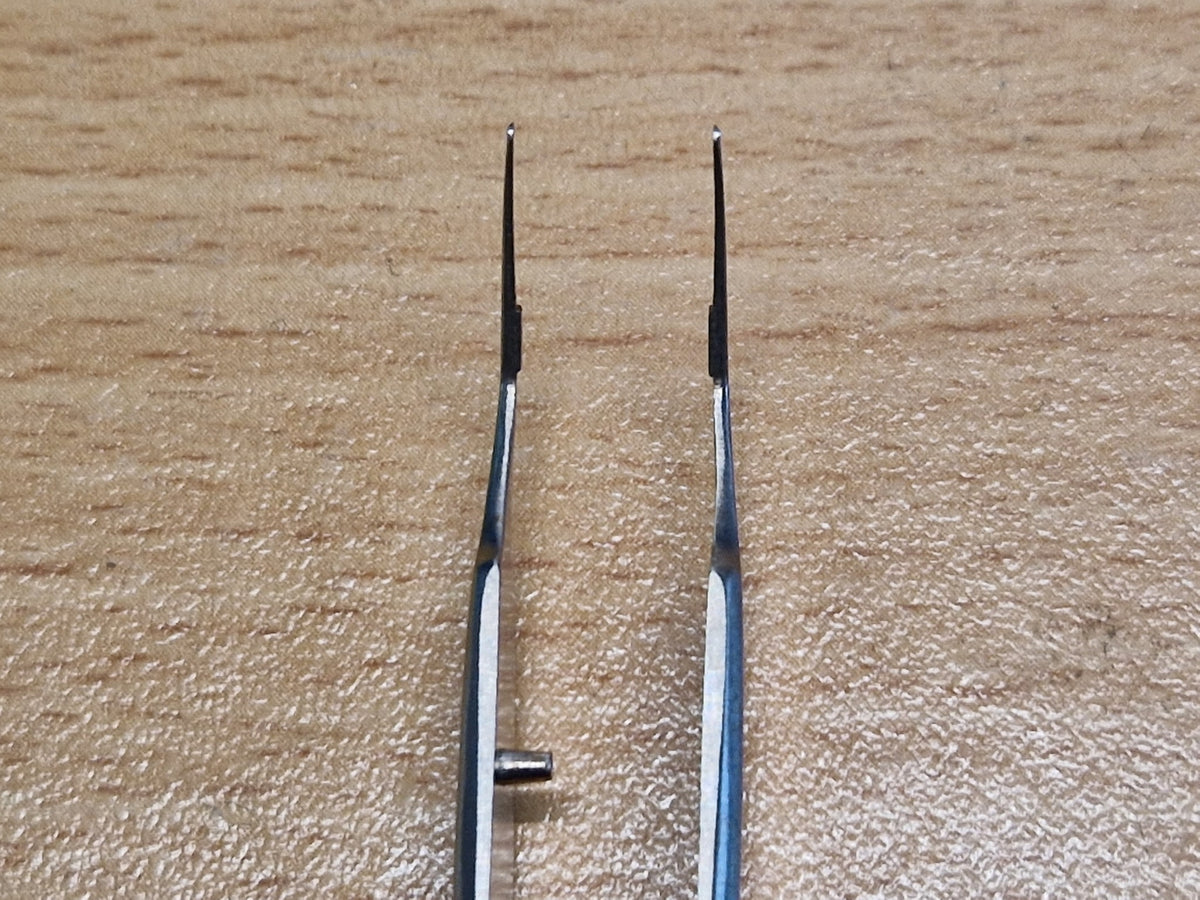 Close-up of fine angled ophthalmic tying forceps tips