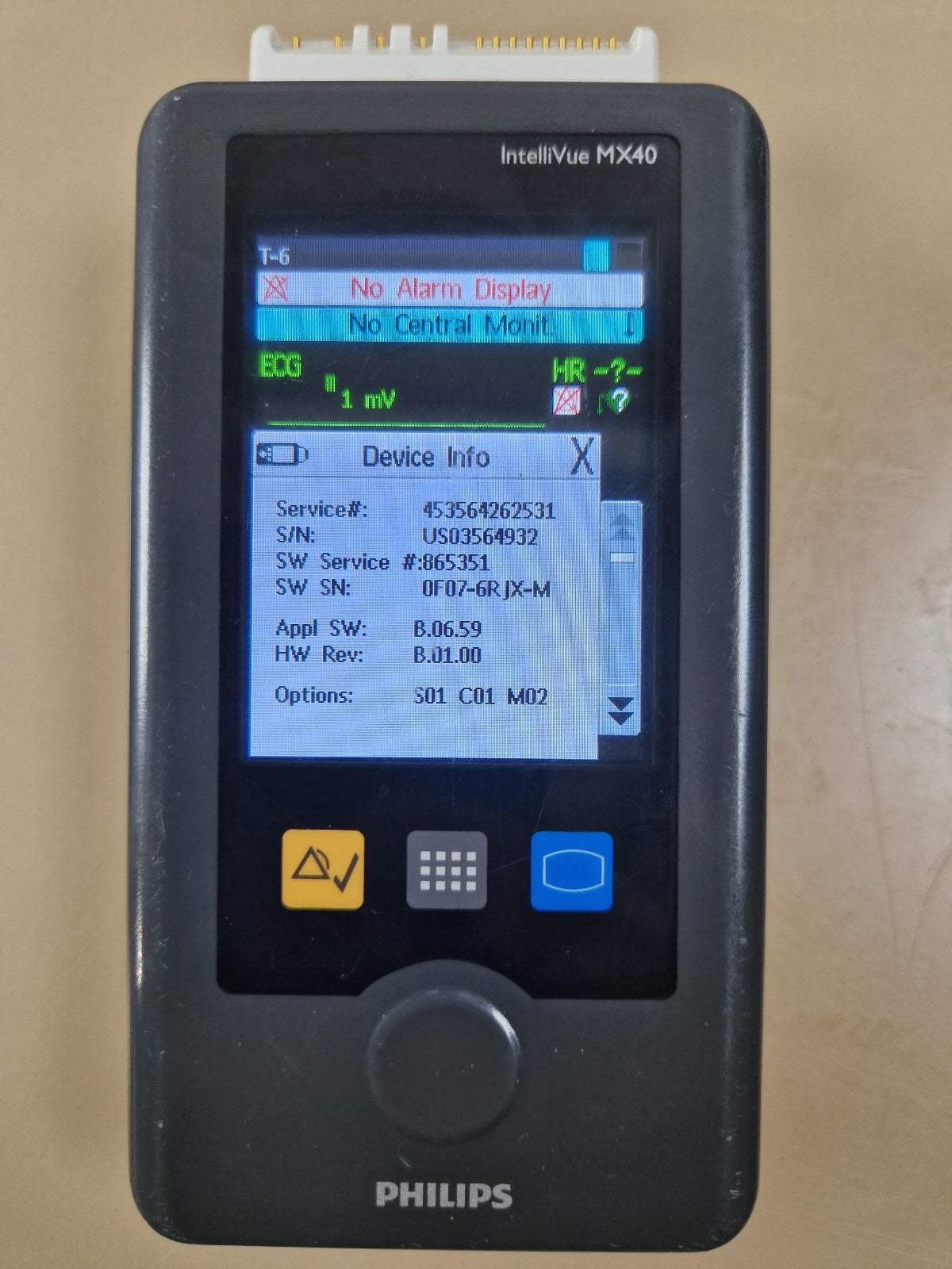 Photographed Philips MX40 Device Info screen showing 865351, software B.06.59 and options S01 C01 M02