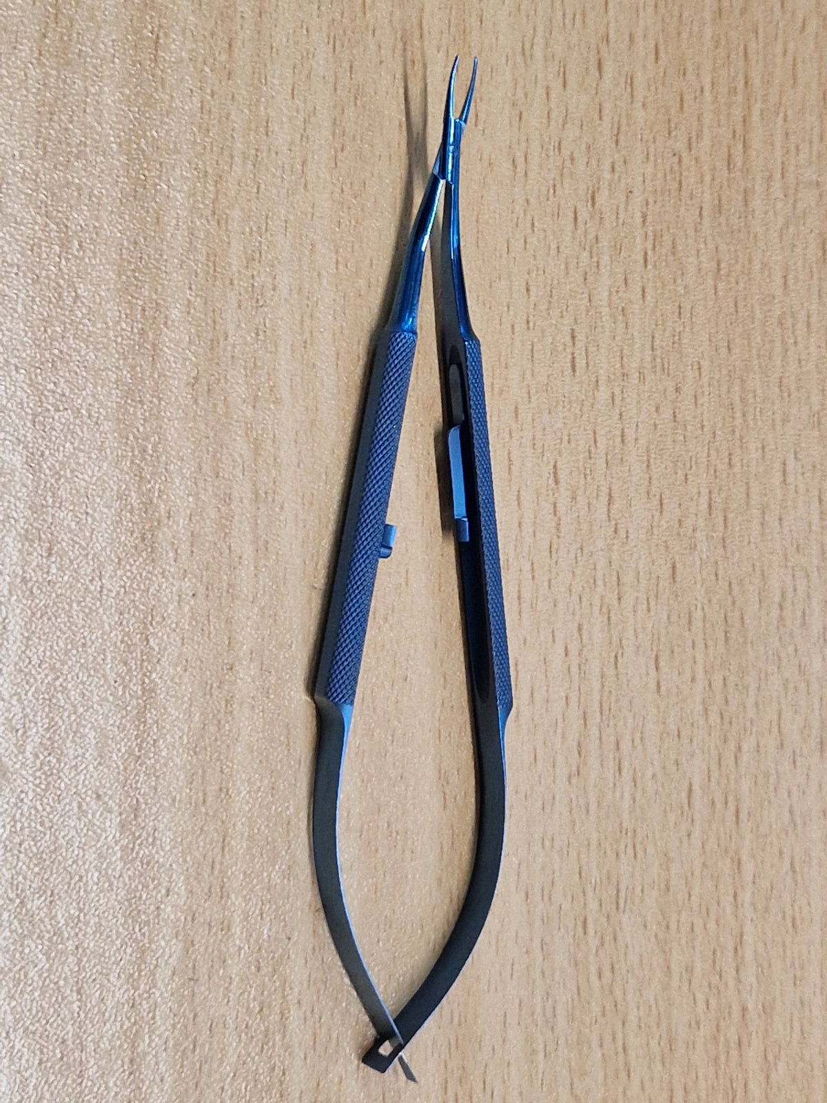Blue titanium Castroviejo-style ophthalmic needle holder with fine straight jaws and spring handle