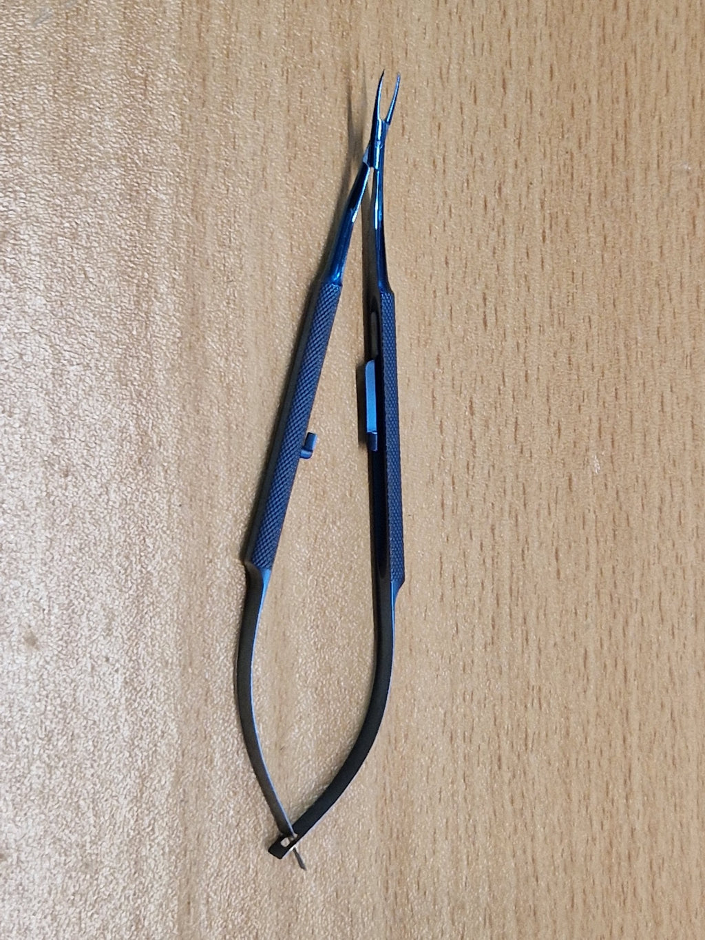 Blue titanium Castroviejo-style ophthalmic needle holder with straight fine jaws and locking spring handle